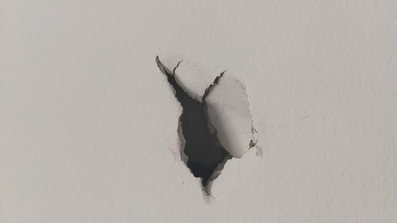 Hole in drywall showing damage and exposed interior, illustrating the need for professional drywall repair services.
